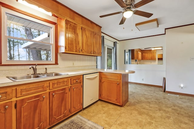 kitchen featuring brown cabinetry, crown molding, light countertops, and a sink