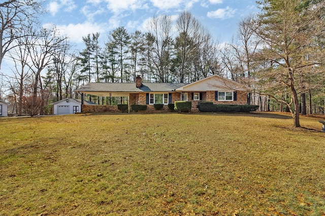 ranch-style home featuring an outbuilding, brick siding, a chimney, and a front yard