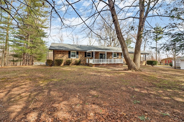 ranch-style home with a porch, brick siding, and a front lawn