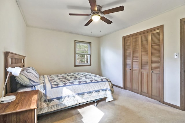 carpeted bedroom featuring ceiling fan, a closet, and baseboards