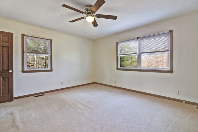 unfurnished room featuring baseboards, a ceiling fan, visible vents, and light colored carpet