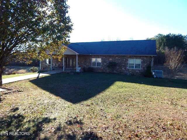 ranch-style house with stone siding and a front lawn