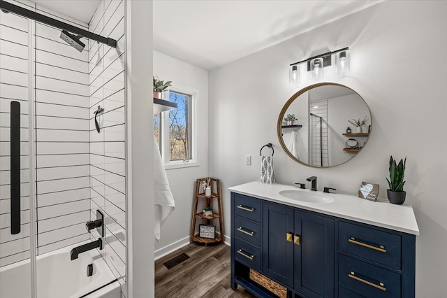 full bathroom featuring shower / bath combination, visible vents, baseboards, wood finished floors, and vanity