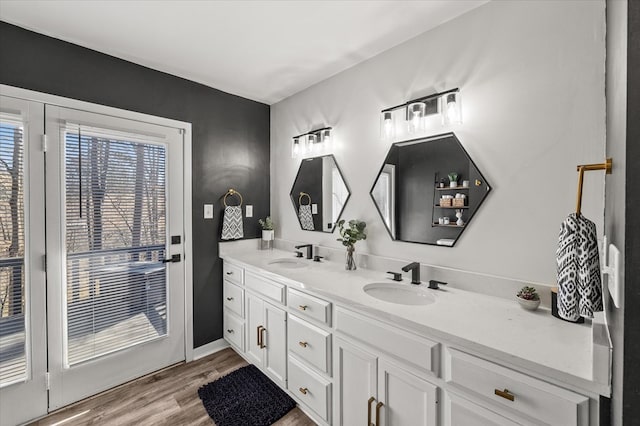 bathroom with double vanity, a sink, and wood finished floors