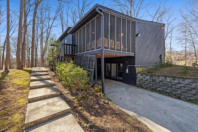 view of front of property featuring stairs and a sunroom