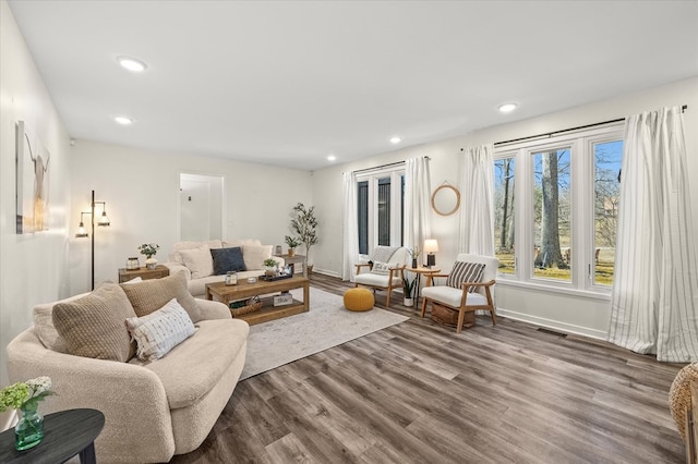 living area with dark wood-style floors, recessed lighting, visible vents, and baseboards