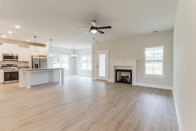 unfurnished living room featuring recessed lighting, a fireplace, visible vents, a ceiling fan, and light wood-type flooring