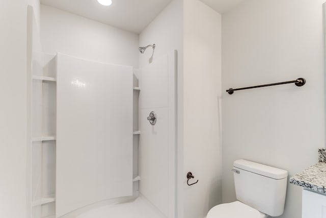 bathroom with walk in shower, vanity, and toilet