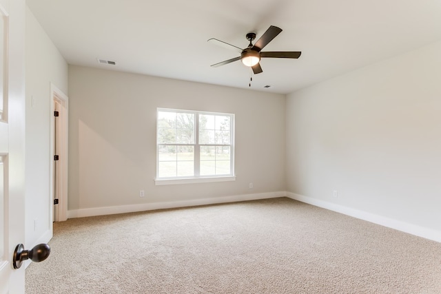 unfurnished room with baseboards, carpet, visible vents, and a ceiling fan