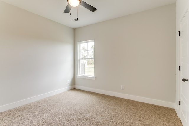 empty room featuring carpet floors, visible vents, ceiling fan, and baseboards