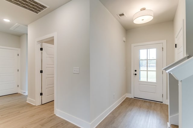 doorway to outside with baseboards, visible vents, and light wood-style floors