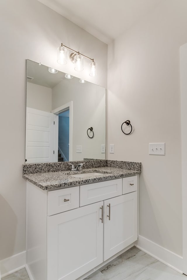 bathroom featuring marble finish floor, vanity, and baseboards