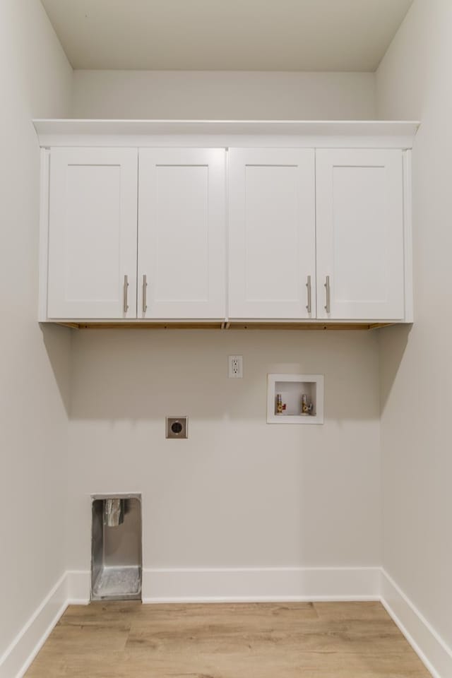 laundry area featuring hookup for a washing machine, light wood-style flooring, hookup for an electric dryer, baseboards, and cabinet space