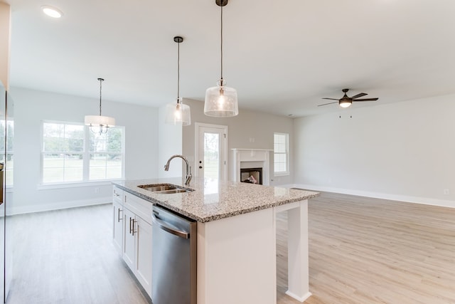 kitchen with a sink, white cabinetry, open floor plan, dishwasher, and an island with sink