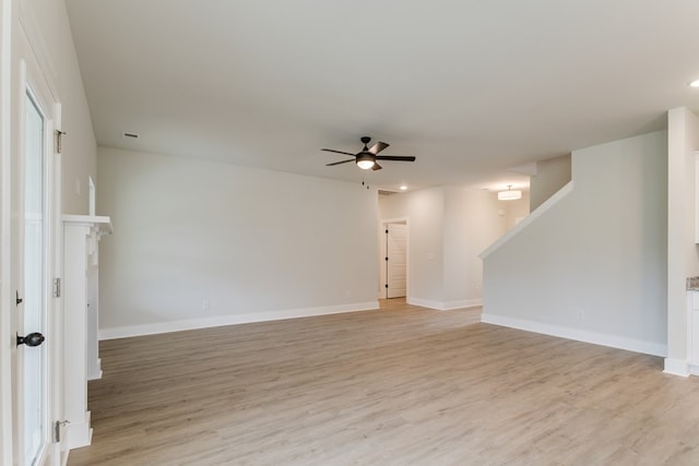 unfurnished room with light wood-style floors, ceiling fan, and baseboards