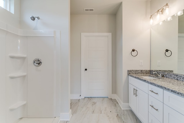 full bath featuring vanity, visible vents, baseboards, marble finish floor, and a shower