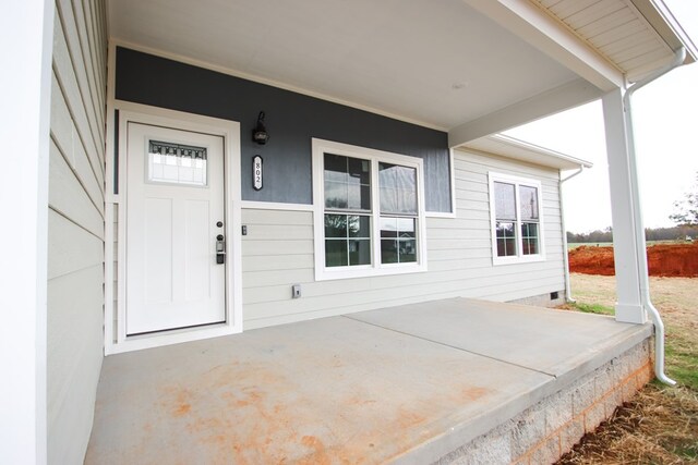 view of exterior entry featuring a patio area