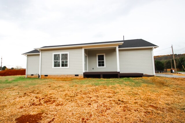 back of property featuring a yard and crawl space