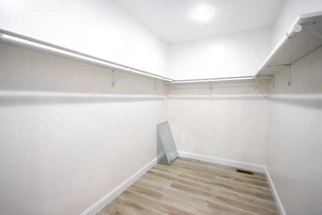 spacious closet featuring light wood-type flooring and visible vents