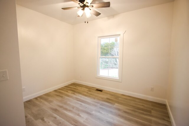 unfurnished room with visible vents, ceiling fan, baseboards, and wood finished floors