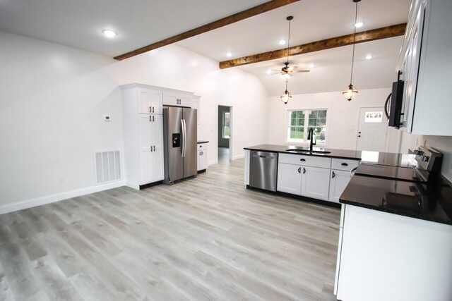 kitchen featuring visible vents, white cabinets, dark countertops, stainless steel appliances, and a sink