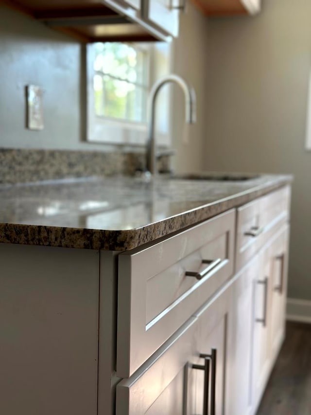 details with a sink and white cabinetry