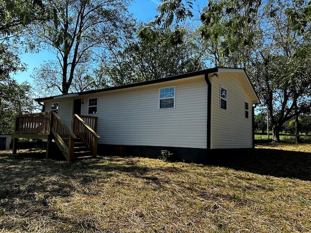 rear view of house featuring a lawn and a wooden deck