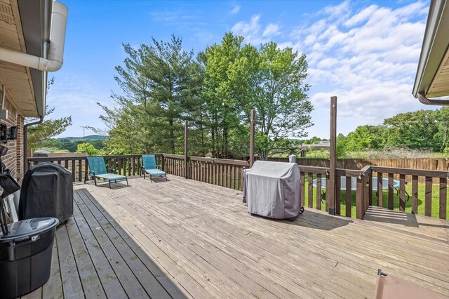 deck featuring fence and a grill