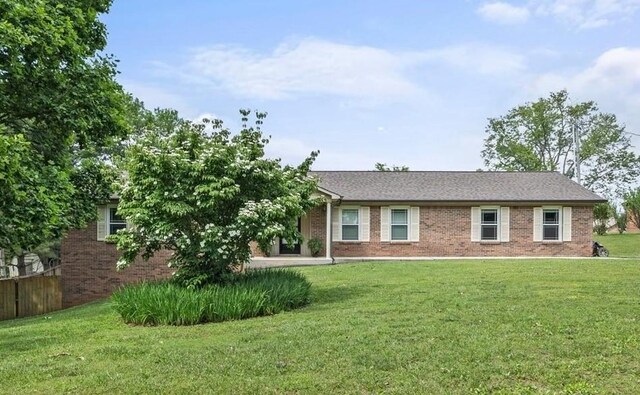 single story home featuring brick siding and a front yard