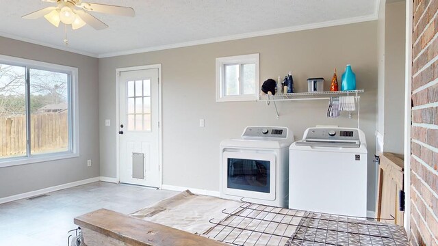 clothes washing area with crown molding, washing machine and clothes dryer, visible vents, laundry area, and baseboards