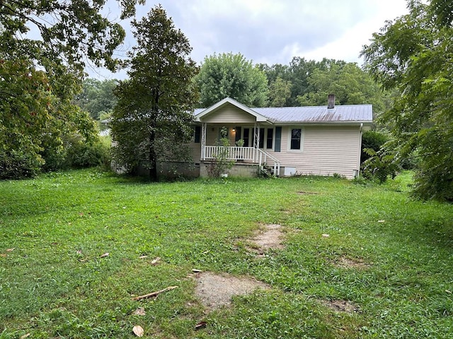 view of front of property with crawl space, covered porch, a front lawn, and metal roof