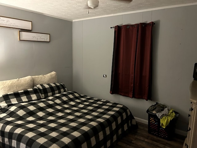 bedroom with ornamental molding, dark wood finished floors, and a textured ceiling