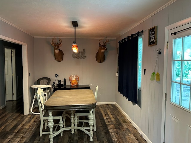 dining room with dark wood-type flooring, crown molding, and baseboards