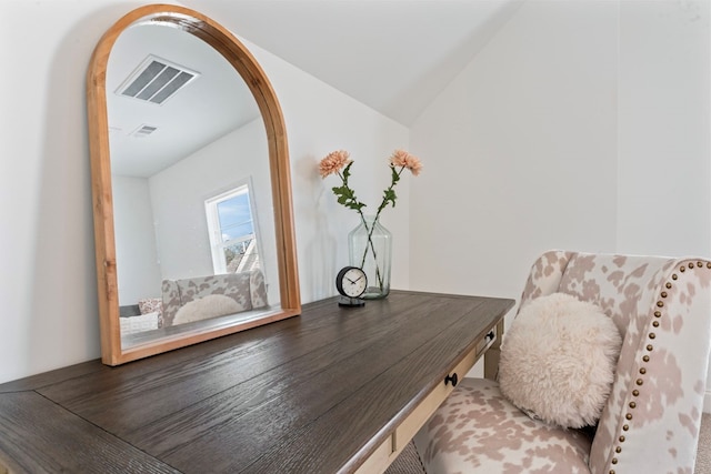 sitting room featuring lofted ceiling, visible vents, arched walkways, and wood finished floors