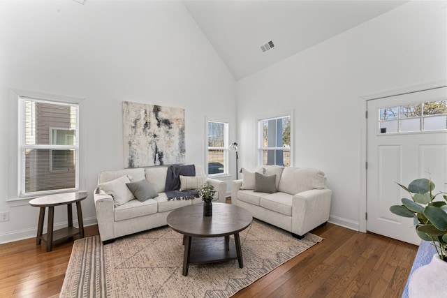 living area featuring high vaulted ceiling, baseboards, visible vents, and wood finished floors