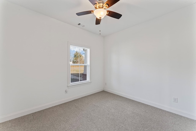 carpeted spare room featuring baseboards, visible vents, and a ceiling fan