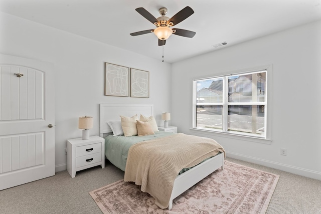 bedroom featuring light carpet, visible vents, baseboards, and a ceiling fan