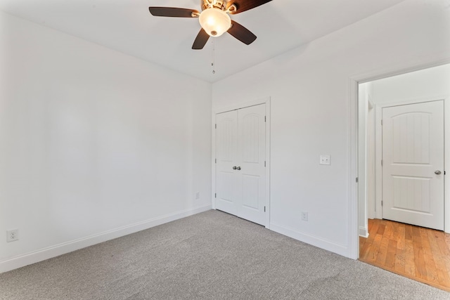 unfurnished bedroom with carpet, a closet, ceiling fan, and baseboards