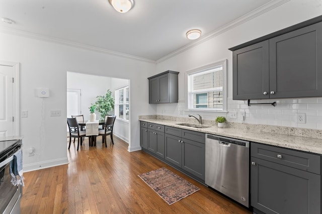 kitchen with stainless steel appliances, gray cabinets, a sink, and dark wood finished floors