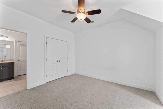 unfurnished bedroom with visible vents, a ceiling fan, light carpet, vaulted ceiling, and baseboards