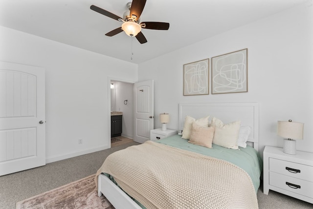 carpeted bedroom with ceiling fan, baseboards, and ensuite bathroom