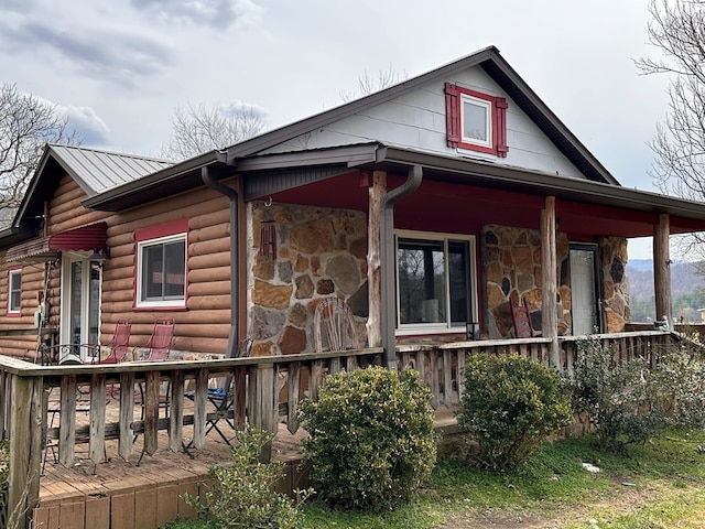 exterior space with covered porch and stone siding