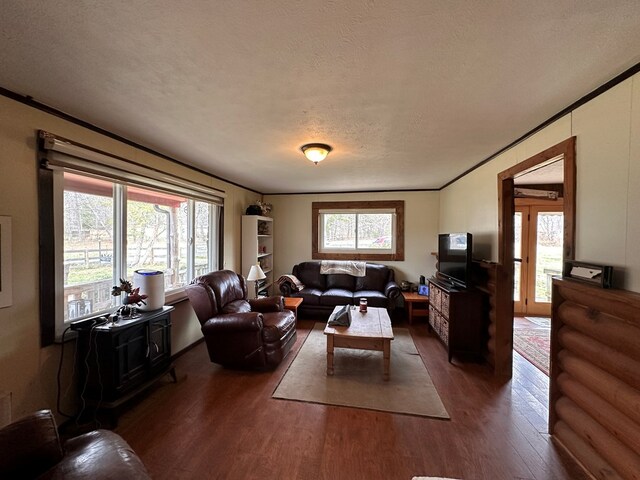 living room with plenty of natural light, wood finished floors, and crown molding