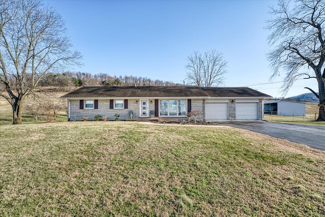 ranch-style home featuring aphalt driveway, a front yard, stone siding, and a garage