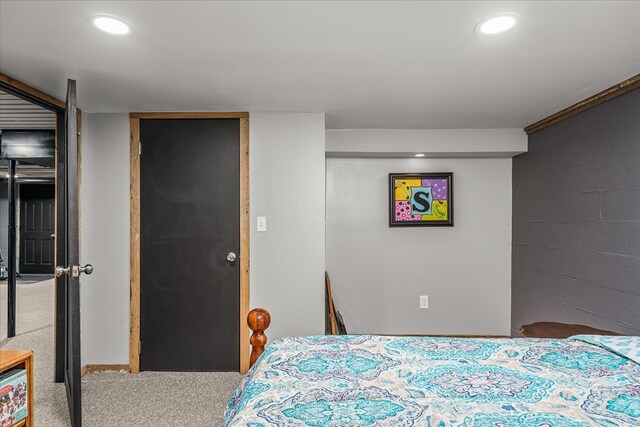 bedroom featuring carpet floors, concrete block wall, and recessed lighting