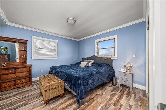 bedroom featuring dark wood-style flooring, crown molding, and baseboards