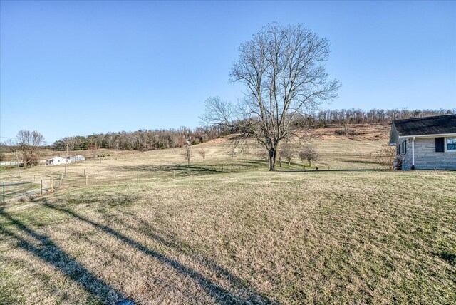 view of yard featuring a rural view and fence