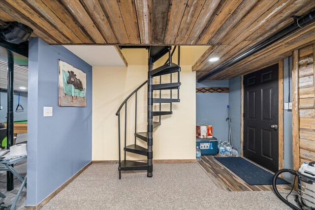 foyer featuring carpet, wood ceiling, stairway, and baseboards