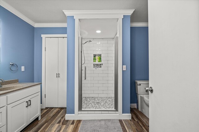 bathroom with a stall shower, crown molding, and wood finished floors