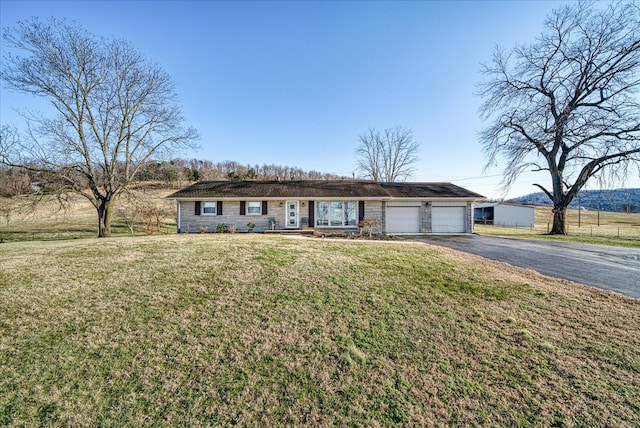 ranch-style home featuring aphalt driveway, a front yard, and an attached garage